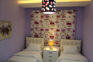 two beds in a room with a wall at Western Gate Residence 1 - Amman, Jordan in Amman