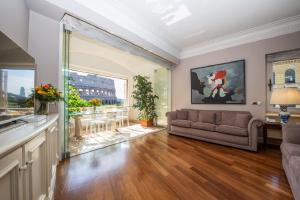 uma sala de estar com um sofá e uma grande janela em 47Luxury Suites - Colosseo em Roma