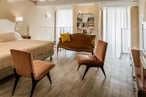 um quarto com uma cama, 2 cadeiras e um sofá em Palazzo Dessy em Cagliari