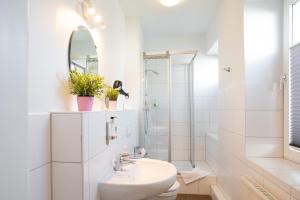 a white bathroom with a sink and a mirror at Wertschätzer III - Paulinenstr in Detmold +20 photos