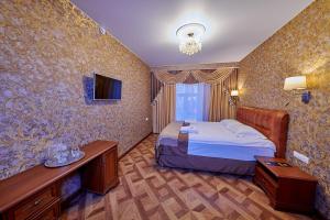 a hotel room with a bed and a television at Реверанс отель in Saint Petersburg