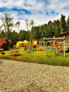 ein Park mit einem Spielplatz mit Rutsche und Schaukeln in der Unterkunft Milleri in Salacgrīva