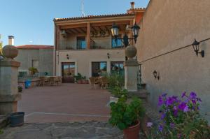 un edificio con un patio con mesas y sillas en La Juderia de Las Arribes, en Vilvestre