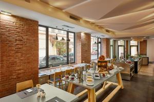 een restaurant met tafels en stoelen en een bakstenen muur bij H+ Hotel Wien in Wenen