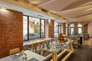 a restaurant with tables and chairs and a brick wall at H+ Hotel Wien in Vienna