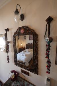 a mirror on a wall with a bed in a room at Nilya Hotel in Selçuk