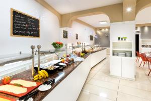 a kitchen with a long counter with food on it at Aparthotel Los Dragos del Sur in Puerto de Santiago