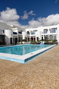 a swimming pool in front of a large building at Vanessa Puerto del Carmen in Tías