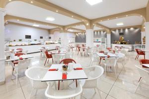 a restaurant with white tables and white chairs at Aparthotel Los Dragos del Sur in Puerto de Santiago