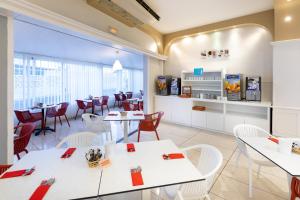 a dining room with white tables and chairs at Aparthotel Los Dragos del Sur in Puerto de Santiago
