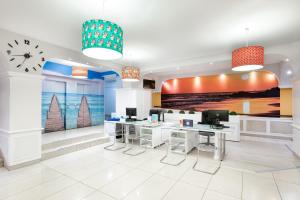 a office with two desks and a clock on the wall at Aparthotel Los Dragos del Sur in Puerto de Santiago