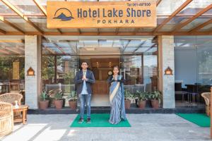 
two women standing in front of a restaurant at Hotel Lake Shore in Pokhara
