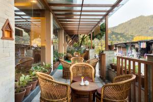 eine Terrasse mit Korbstühlen und einem Tisch auf dem Balkon in der Unterkunft Hotel Lake Shore in Pokhara