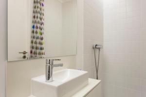 Baño blanco con lavabo y espejo en Severa Apartments en Lisboa