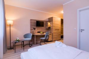 Una habitación de hotel con una cama, una mesa y sillas. en Hotel Linderhof, en Erfurt