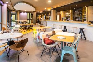 un restaurant avec des tables et des chaises ainsi qu'un bar dans l'établissement ibis Zürich Messe Airport, à Zurich