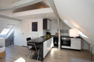 a kitchen with white cabinets and a black counter top at Wertschätzer II - Unter der Wehme in Detmold