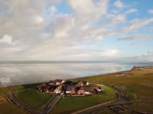 an aerial view of a house next to the water at Kapitänshaus Meerblick in Langeneß
