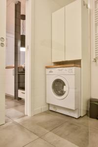 a white kitchen with a washing machine in a room at Smulikowskiego 2 in Warsaw