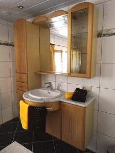 La salle de bains est pourvue d'un lavabo et d'un miroir. dans l'établissement Apart Beate, à Feichten Im Kaunertal