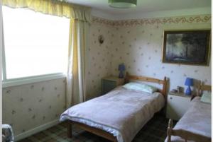 a small bedroom with a bed and a window at Braeside Craighouse Jura in Craighouse