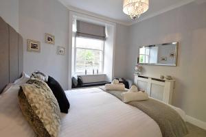 a bedroom with a large white bed with a chandelier at JOIVY Heart of the Old Town Literally under the Castle in Edinburgh