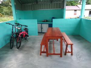 two bikes parked next to a table and a bench at Tanjong Tinggi Cottage in Sijuk