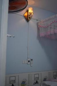 una camera da letto con una luce sul muro e una finestra di Bai Huong homestay a Hoi An