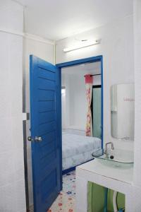 a blue door leading to a bathroom with a sink at Fufu In Love in Khao Kho