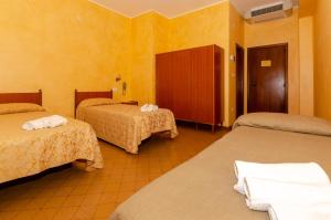 Magliano deʼ MarsiにあるHolidayの黄色の壁のホテルルーム(ベッド3台付)