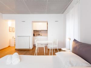 ミラノにあるeasyhomes - Spiga Suiteの白いベッドルーム(テーブル、椅子付)、キッチン