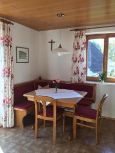 a dining room with a table and chairs and a cross on the wall at Ferienwohnung Albrecht in Dornbirn