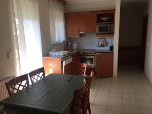 cocina con mesa y sillas y cocina con fogones en Vízközeli panorámás 4 fős apartman Badacsonytomajon, en Badacsonytomaj