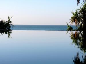 a swimming pool with the ocean in the background at 3 Sisters Beach House in Matara
