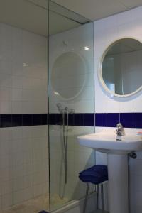 y baño con lavabo y ducha con espejo. en Bungalow Hotel Port-Lligat, en Cadaqués