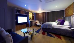 a hotel room with a bed and a flat screen tv at Malmaison London in London