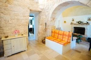 uma sala de estar com um sofá e uma parede de pedra em Trullo San Giovanni em Ceglie Messapica