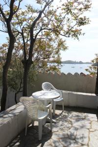 two chairs and a white table and chairs on a patio at Bungalow Hotel Port-Lligat in Cadaqués