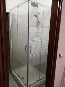 una porta doccia in vetro con un uccello sopra di B&B Casa William a Castellammare di Stabia