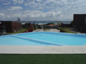 a large blue swimming pool with green grass at Condomínio Veloso in Cidade de Nacala