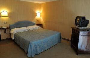 Un pat sau paturi într-o cameră la Grande Albergo Quattro Stagioni