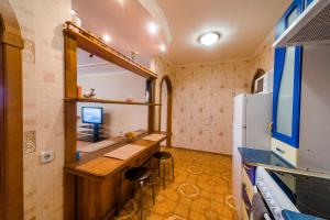 トムスクにあるБольшая Подгорная 57 квартира-студия с утепленной лоджиейのデスク、冷蔵庫が備わる小さな客室です。
