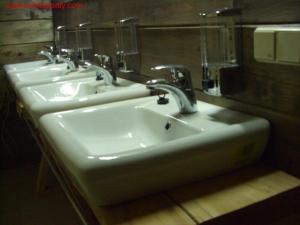 a bathroom with three sinks and two mirrors at хостел "Трутень" in Vorokhta
