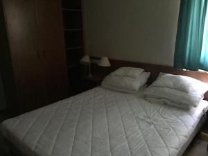 1 dormitorio con 1 cama blanca y 2 almohadas en Strandközeli panorámás 4 fős apartman Badacsonytomajon en Badacsonytomaj