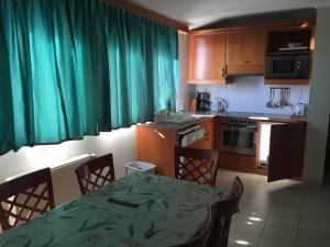 バダチョニトマイにあるStrandközeli panorámás 4 fős apartman Badacsonytomajonのキッチン(テーブル、椅子、緑のカーテン付)