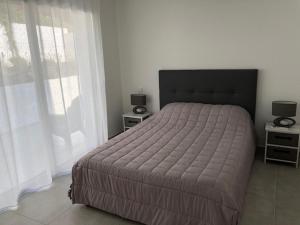 サリ・ソランザラにあるSOLEIL ROUGEのベッドルーム1室(大型ベッド1台、ナイトスタンド2台付)