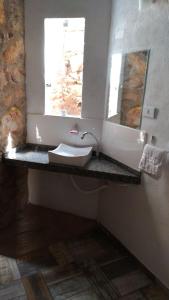 uma casa de banho com um lavatório e uma janela em Art Hotel Cristal de Igatu em Igatu