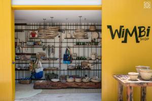 a room with a yellow wall with a shelf with baskets at Zuri Zanzibar in Kendwa