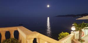 a view of the ocean from a balcony at night at Hotel Grifeu in Llança