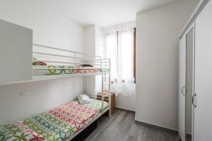 ein kleines Schlafzimmer mit einem Etagenbett und einem Fenster in der Unterkunft Appartamento Balkissa in San Felice del Benaco
